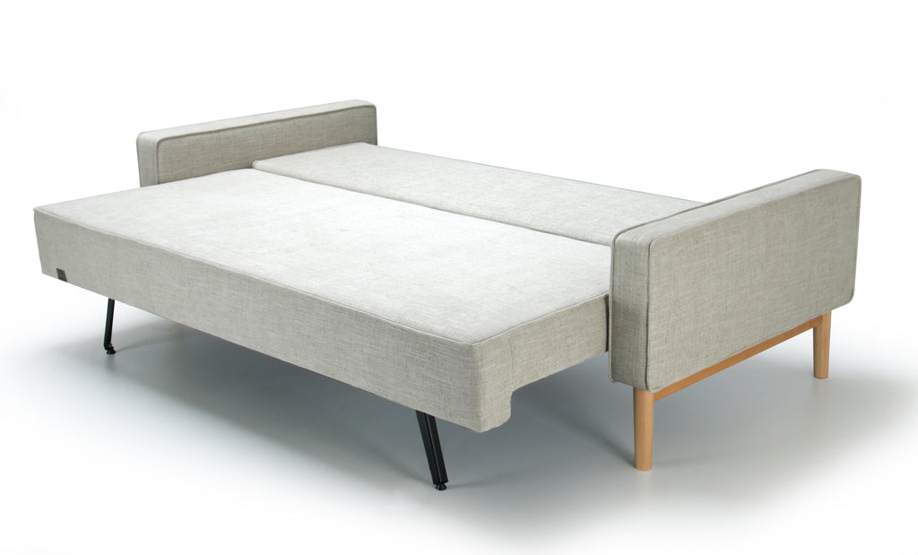 Side view of white extended Alpine sofa bed with upholstered armrest on a white background.
