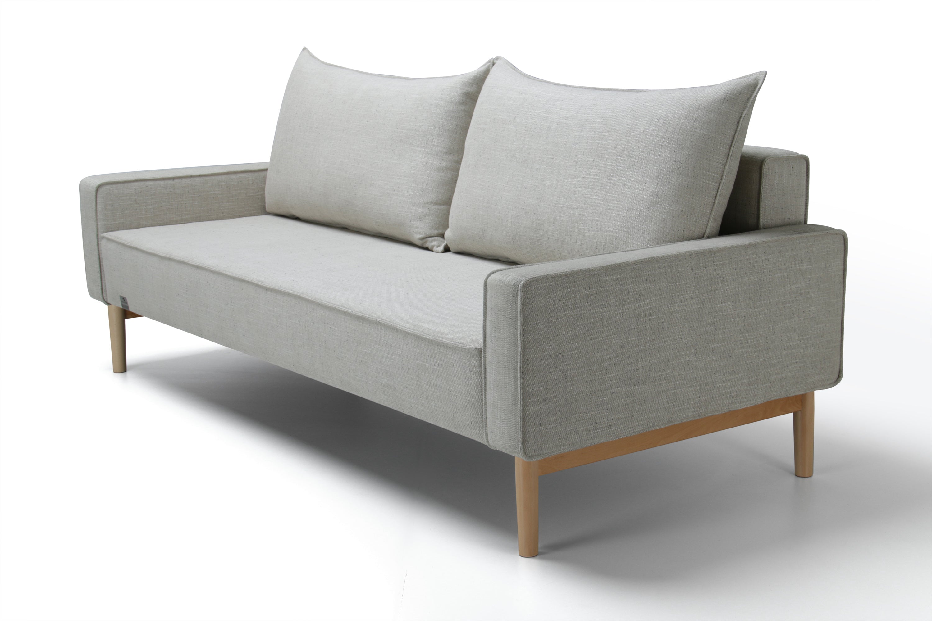 Side view of white Alpine sofa bed with upholstered armrest on a white background.