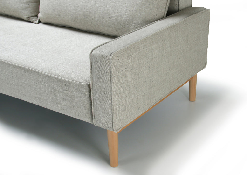 Detail view of white Alpine sofa bed with upholstered armrest on a white background.