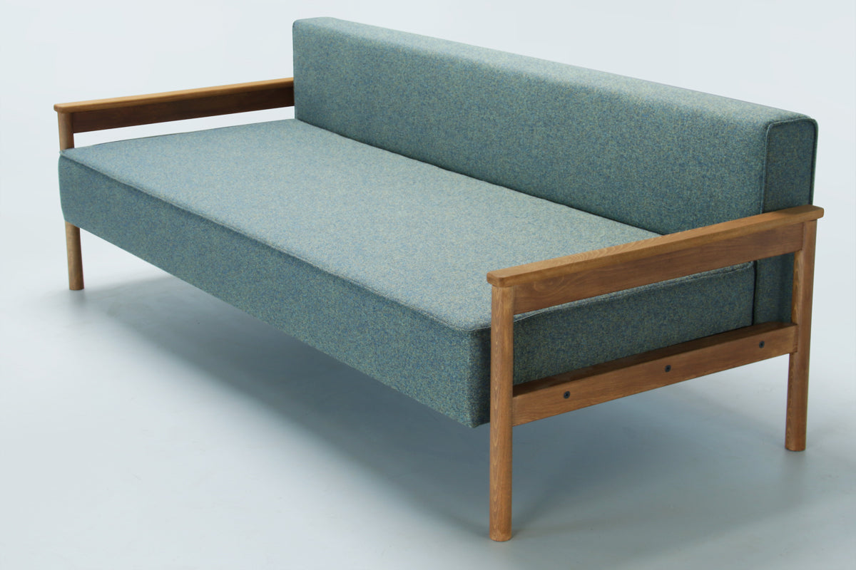 Green Alpine sofa bed with wooden armrest on a white background without back pillows.
