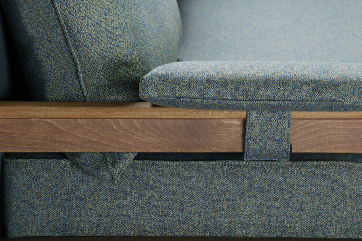 Close side view of green Alpine sofa bed with wooden armrest.
