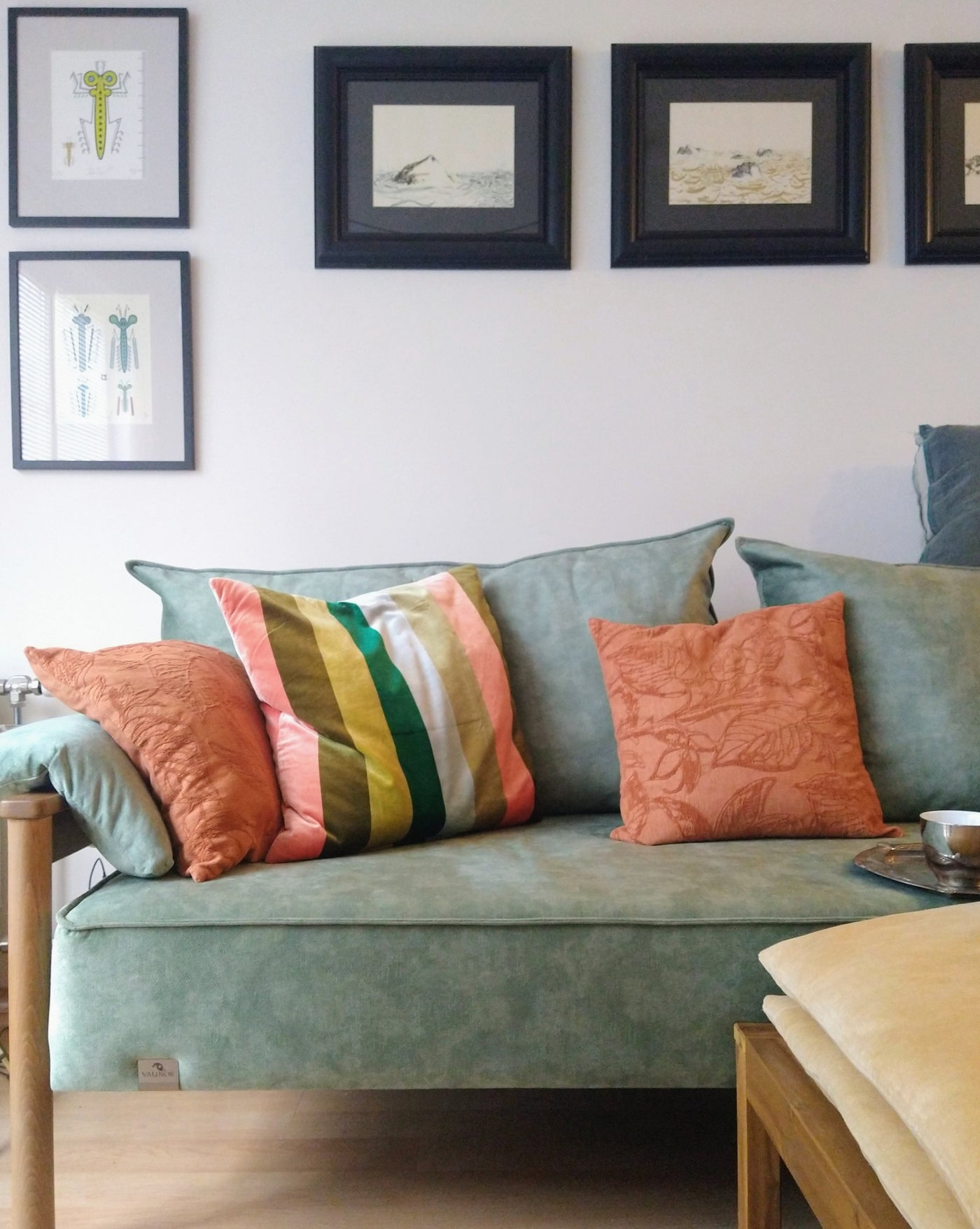 Light blue Alpine sofa bed with colorful pillows in a living room setting.