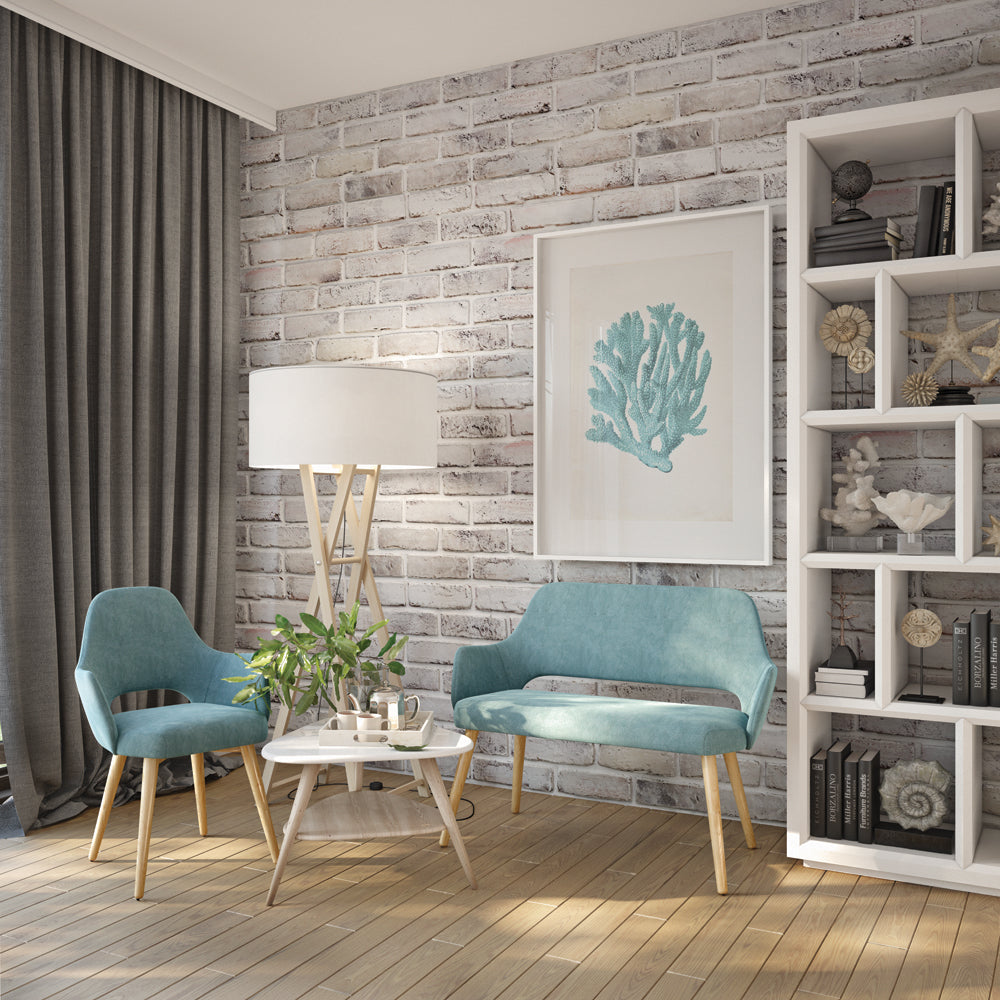 Living room with blue Andre chair, Andre sofa and wooden table featuring a bowl of fruit and a plant.