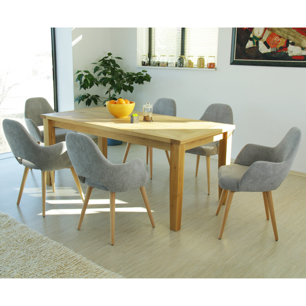 Dining room with wooden table and gray Andre chairs, featuring a bowl of fruit and a plant.