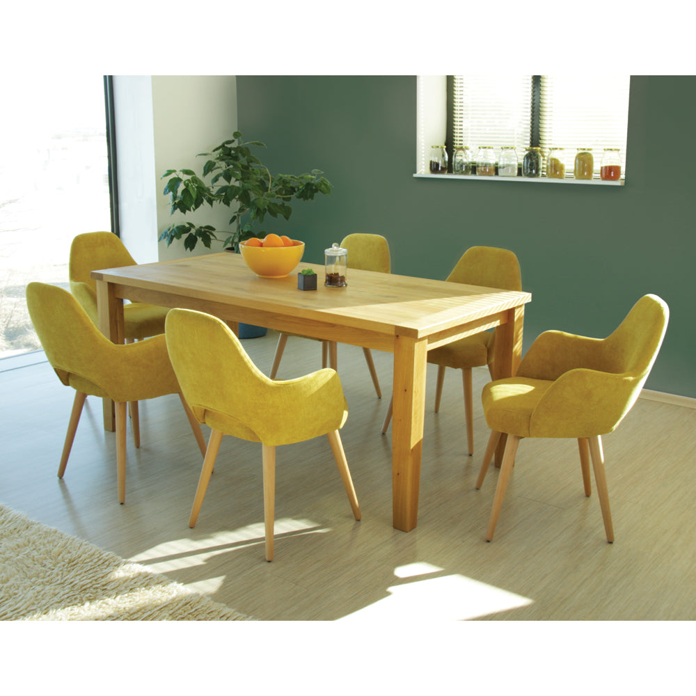 Dining room with wooden table and yellow Andre chairs, featuring a bowl of oranges.