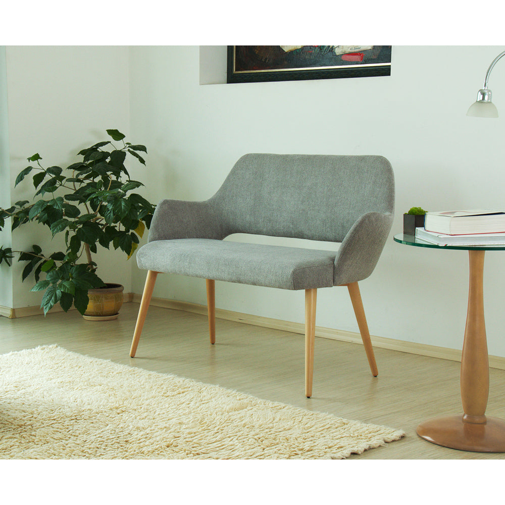 Gray Andre upholstered sofa in a room with a plant and small table.