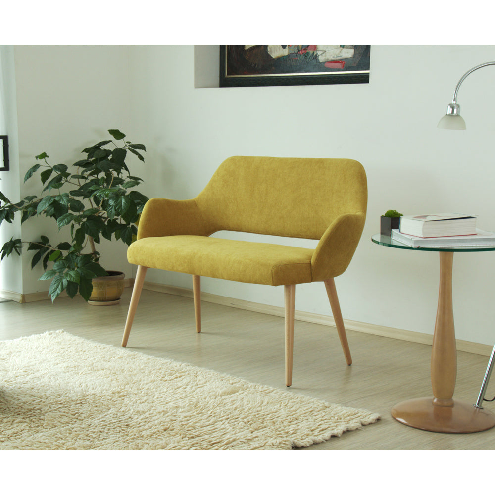 Yellow  Andre sofa in a living room setting with a plant and small table.