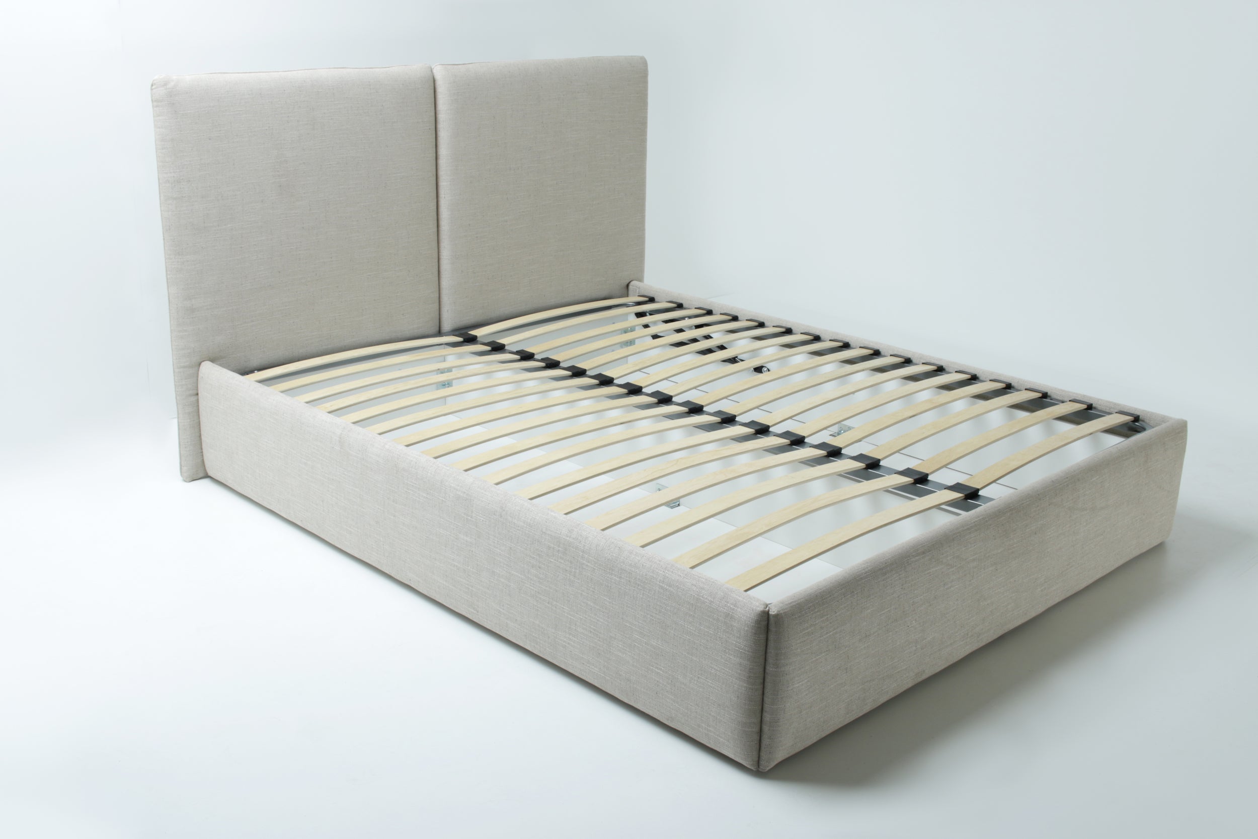 A large  beige upholstered bed frame with a tall headboard and wooden slats, shown on a white background.