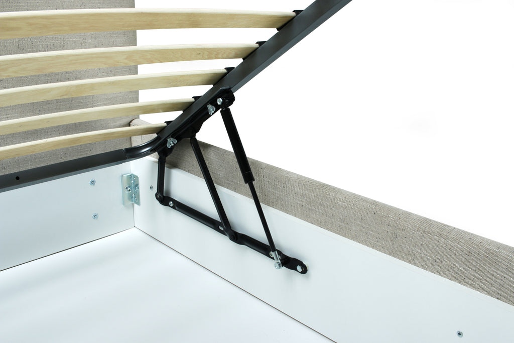 Close-up of a bed frame mechanism with light wood slats, black metal support arms, and a white headboard against a white background.