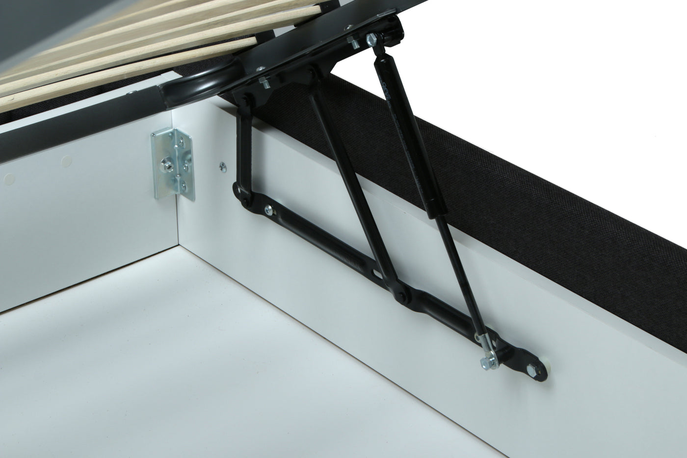 Close-up of a black metal bed frame support bracket and gas lift mechanism attached to a white bed frame corner, with wooden slats visible at the top.