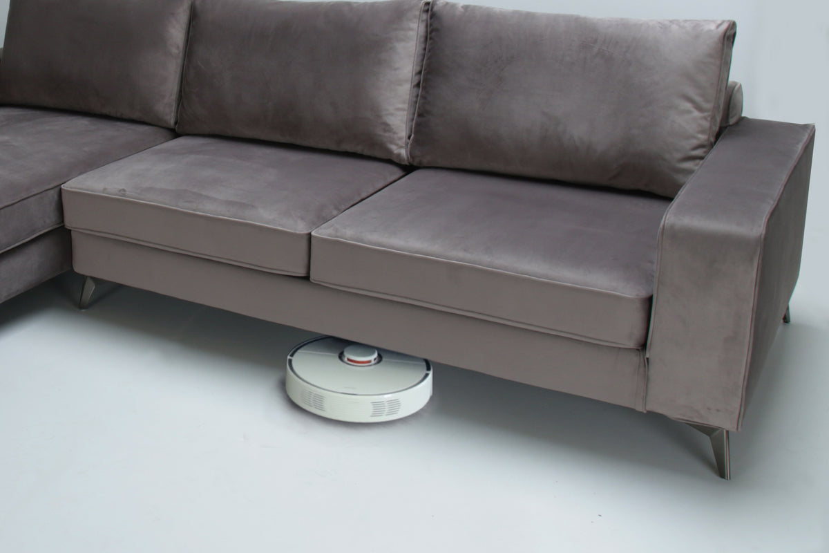 Robotic vacuum cleaner on a white floor bellow left side corner sofa, model Connor - brown color on a white background.