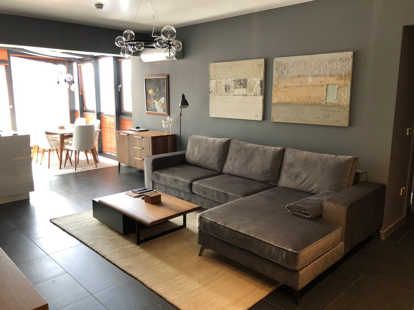 Modern living room with a gray sectional Connor sofa, coffee table, and wall art.
