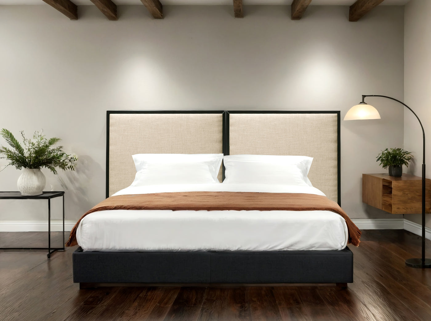 Modern bedroom with a bed, headboard with a beige upholstery and black frame, nightstands, and decorative elements.