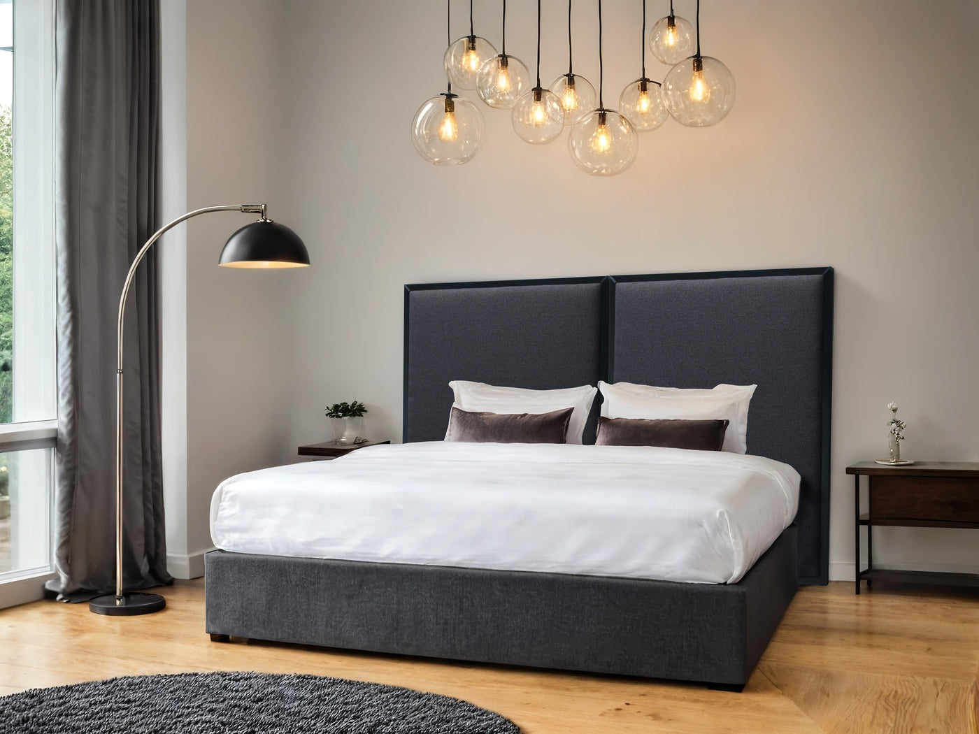 Modern bedroom with a black upholstered bed, headboard with a dark grey upholstery and black frame, white bedding, and decorative lighting.