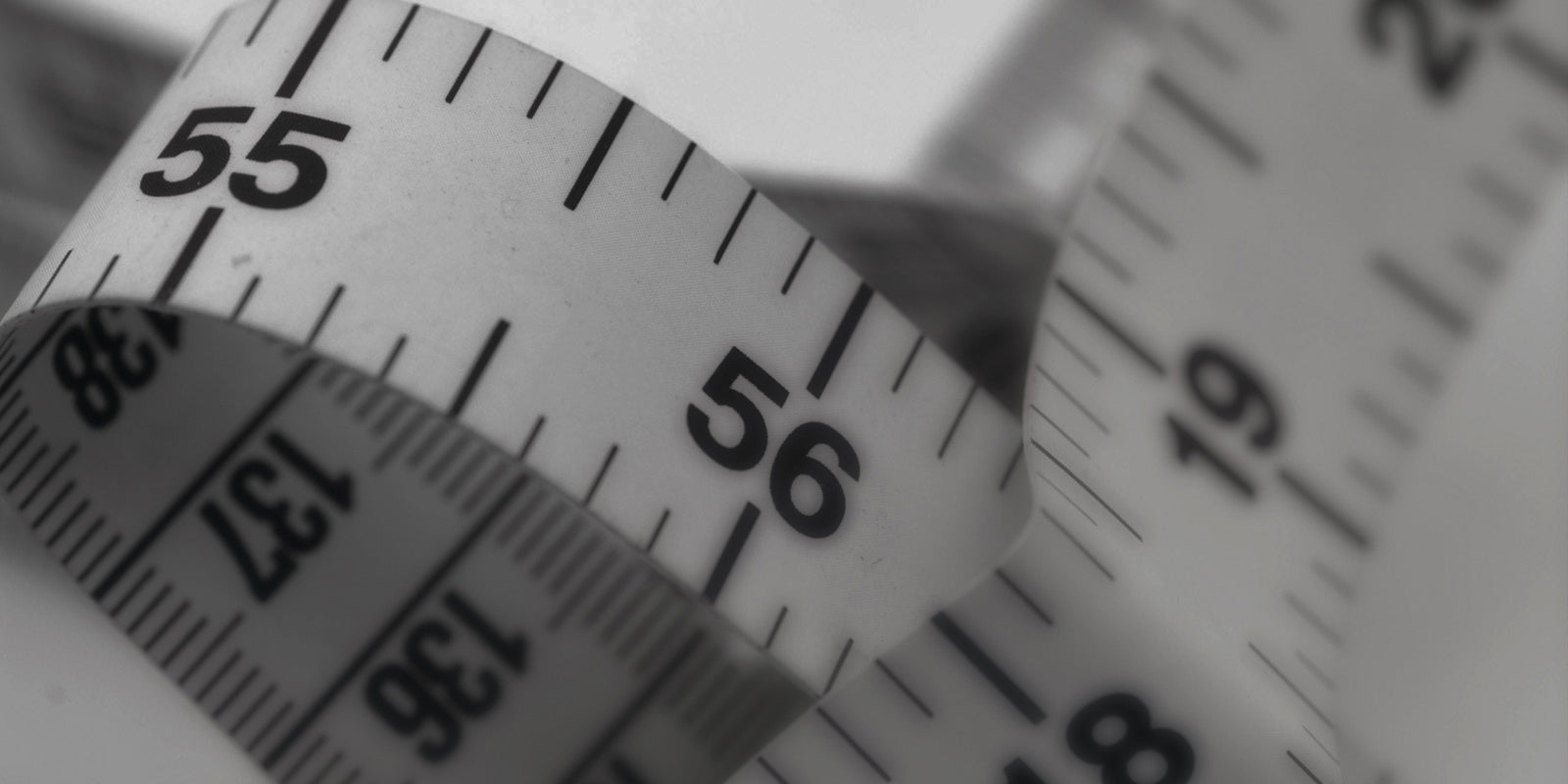 Close-up of a measuring tape with numbers on a white background