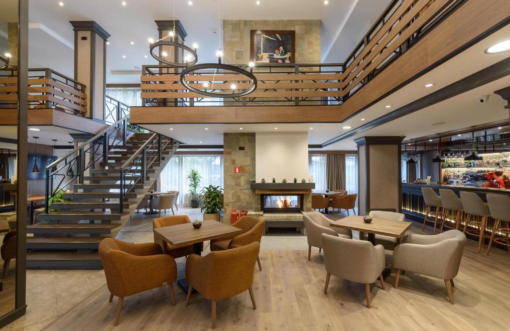 Modern interior of a hotel lobby  with wooden floors, tables, and Juno armchairs.