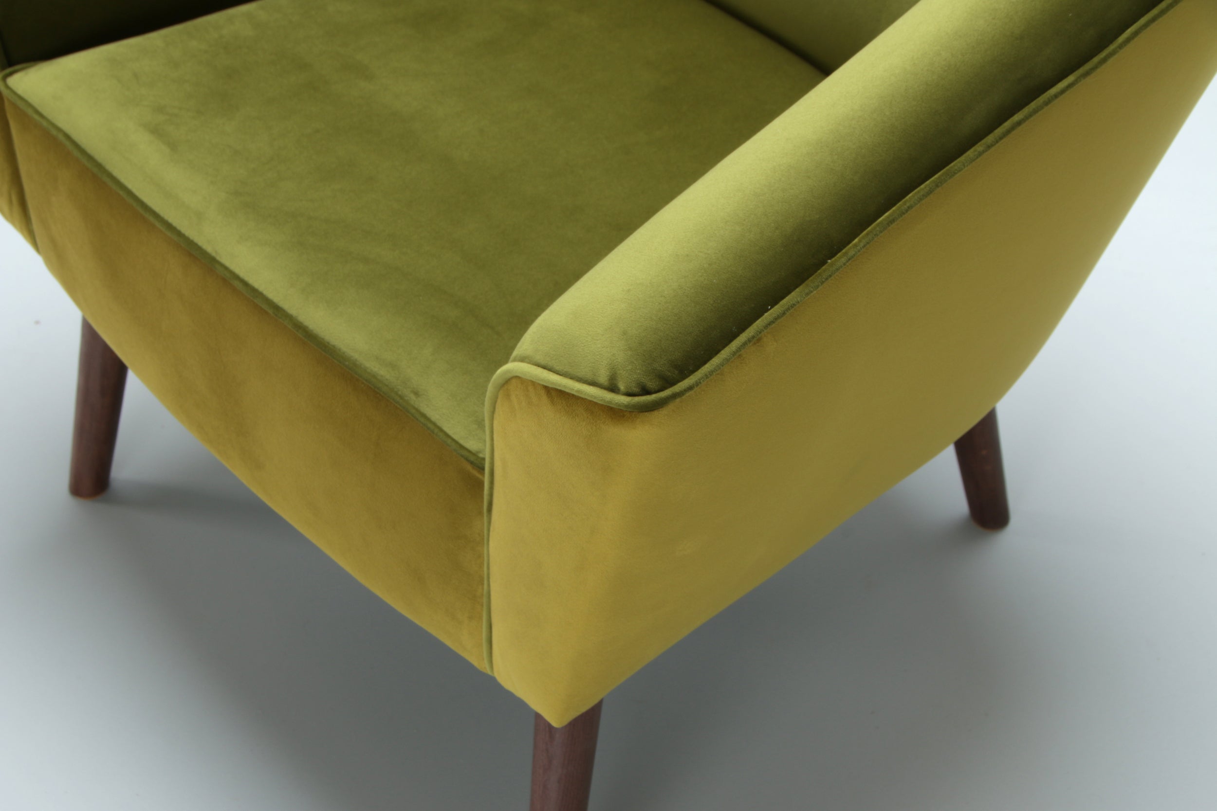 Green armchair Leonardo with wooden legs on a white background -armrest close view