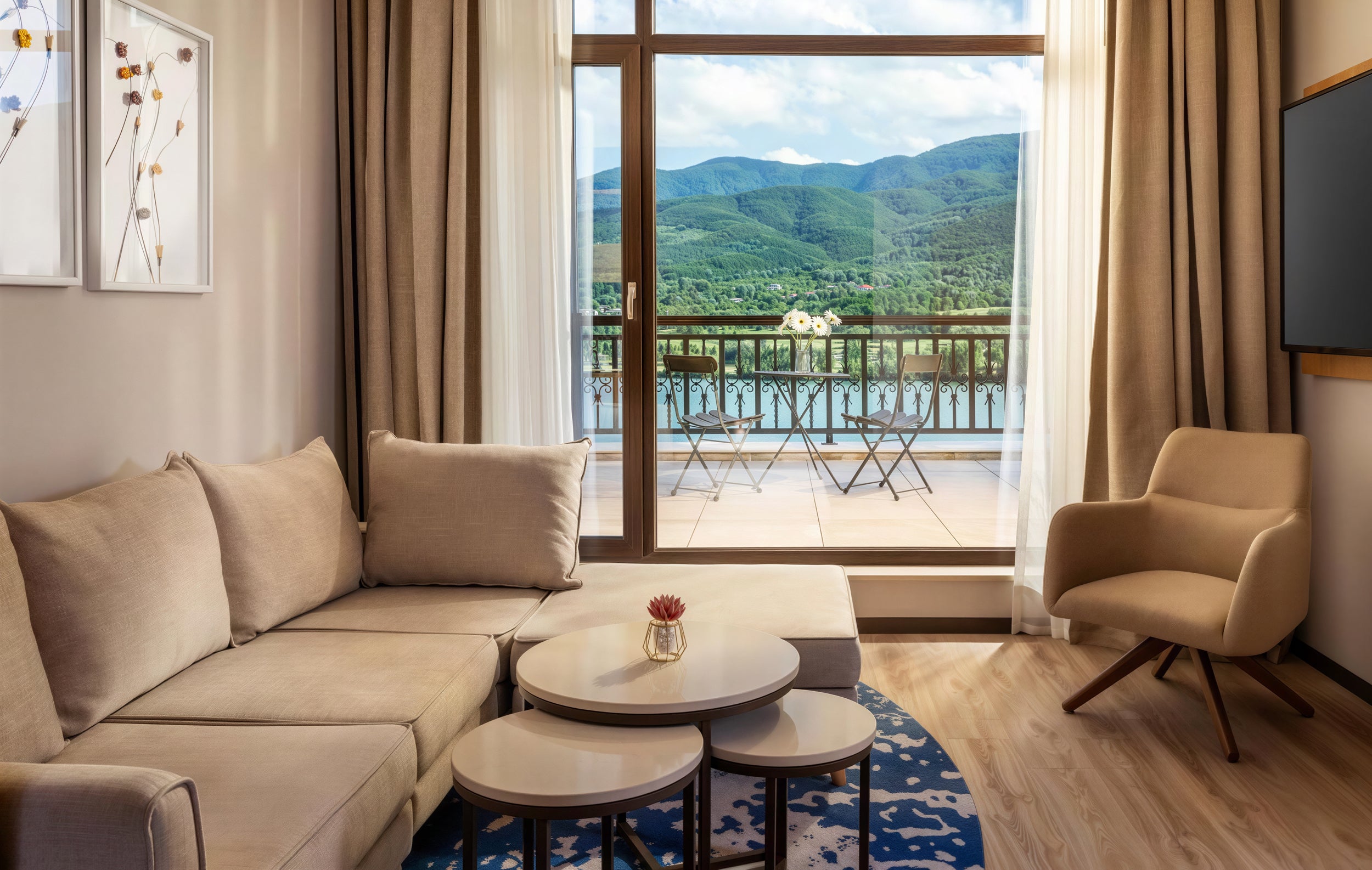 Modern hotel room with a Lucas sofa and a view of mountains and a lake.