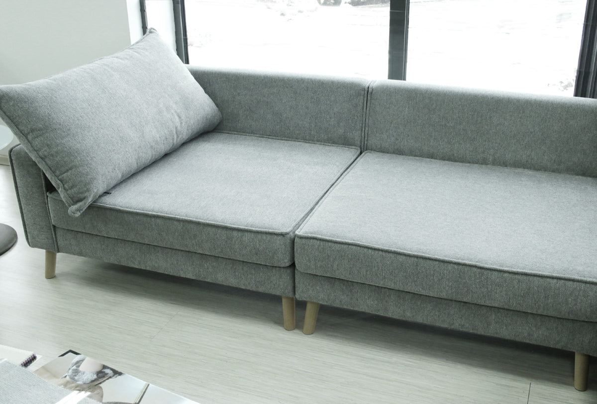 Gray sectional Lucas sofa without back pillows in a room with large windows.