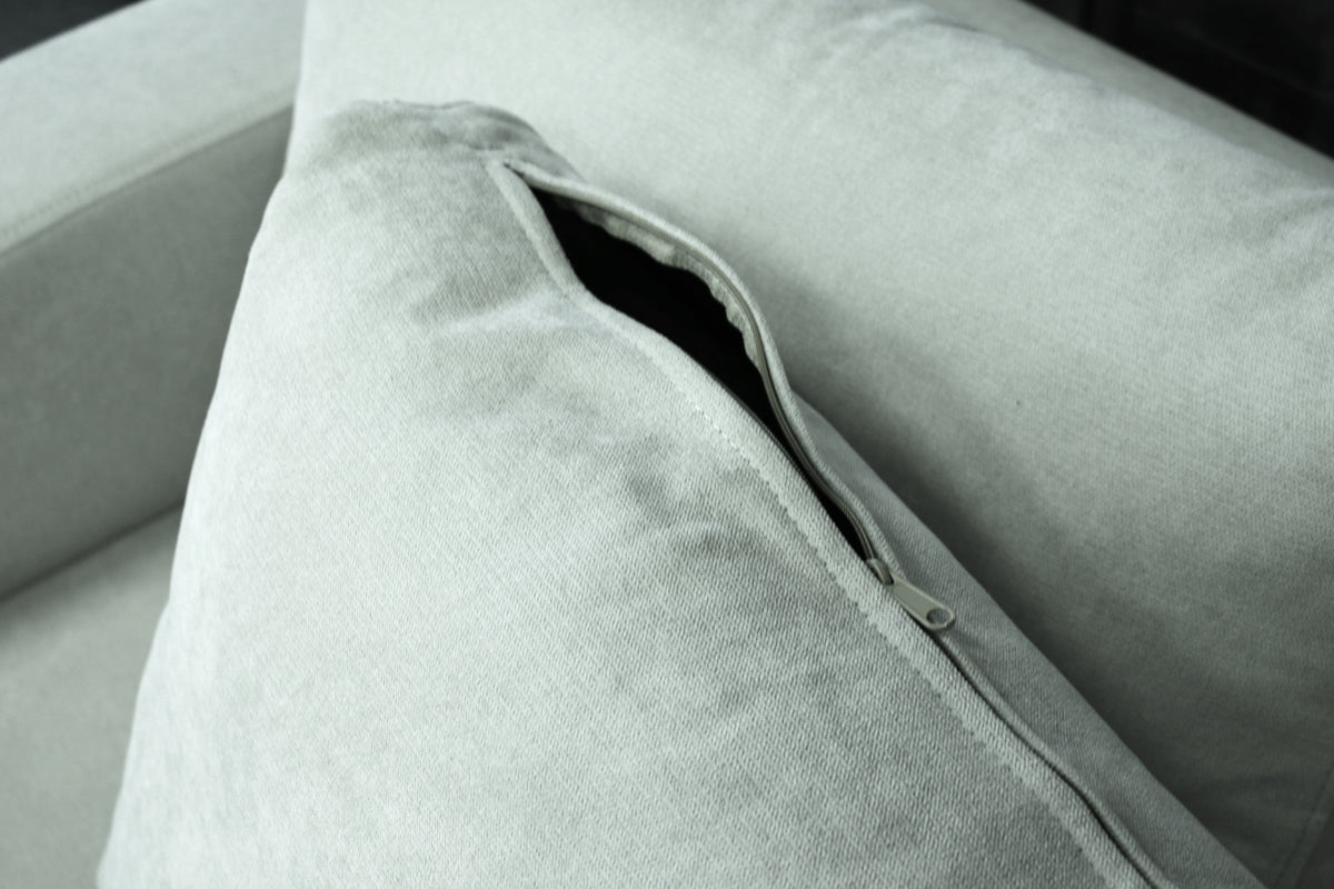 Close-up of a light gray fabric pillow of MAX sofa, with a open zipper.